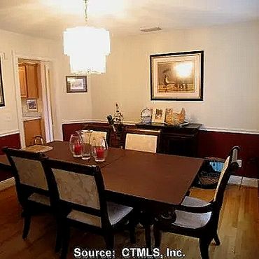Dining room with custom Harwood floors,  Windsor trim and door casing finished off with a chair rail