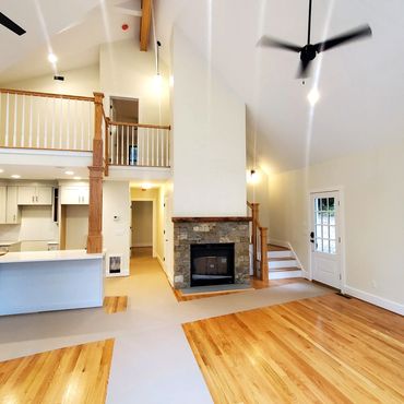 Red oak hardwood flooring with a dry stack custom New England Stone work fireplace, a bluestone hear