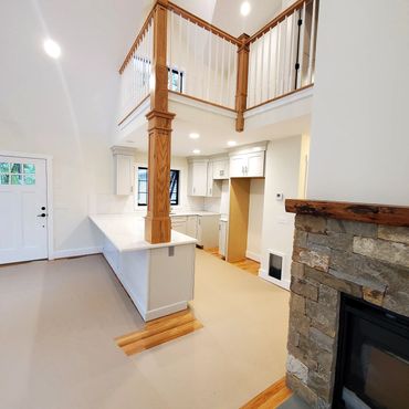 Custom built Hardwood column supporting balcony above. Thompson New England Stone fireplace with a f