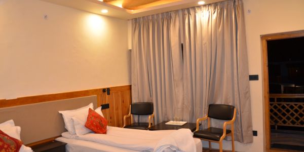 Cozy hotel room with twin beds and seating area by the window.