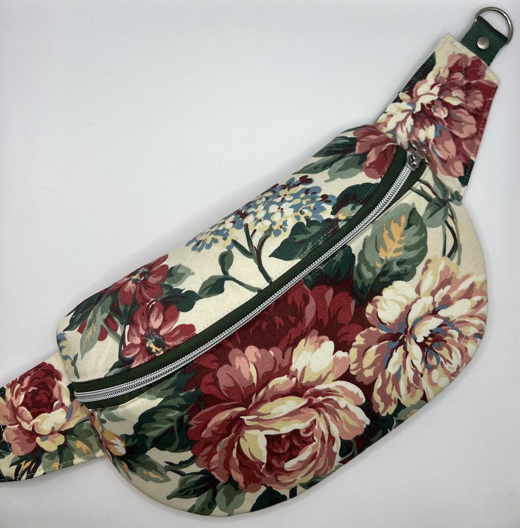 A floral crossbody sling bag in rich reds, greens, pinks and cream. 