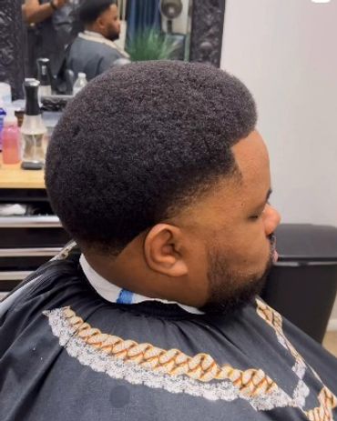 Man with a rounded afro haircut in a barbershop.