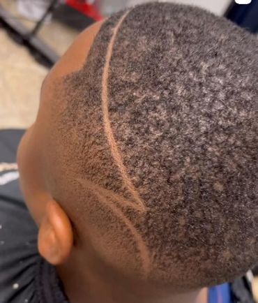 Close-up of a fresh haircut with a unique curved shaved design.