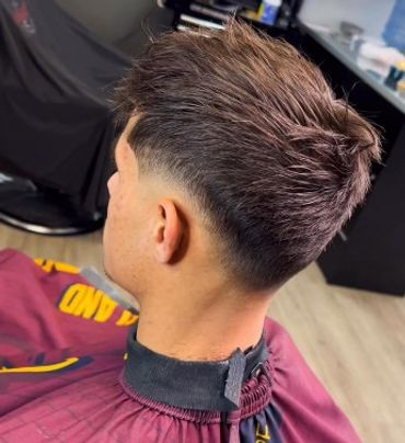 Tapered haircut with textured top and clean fade on the sides.
