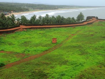 Coastal fort with green grass and palm trees.