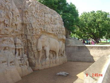 Ancient rock carving of elephants and other figures in a historic site.