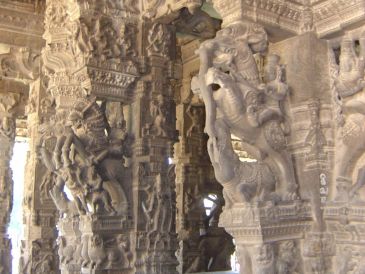 Intricate stone carvings on pillars in an ancient temple.