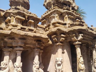Ancient stone temple with intricate carvings under clear sky.