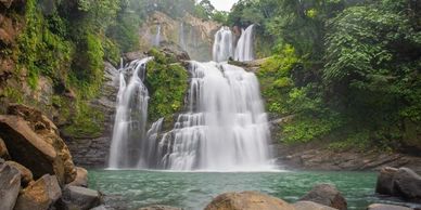 Multiple-tier waterfall cascading into a rocky pool.