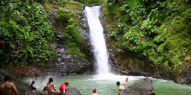 Waterfall with people swimming.
