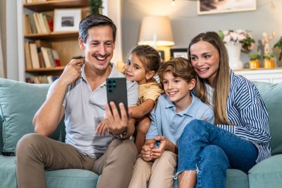 Família sorridente fazendo videochamada.