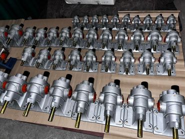 Multiple silver mechanical parts neatly arranged on a wooden surface.