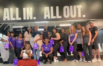 Group photo of people in a gym with motivational signs.