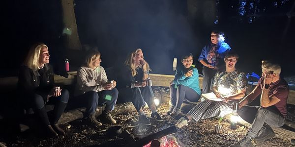 Group of adults around a campfire