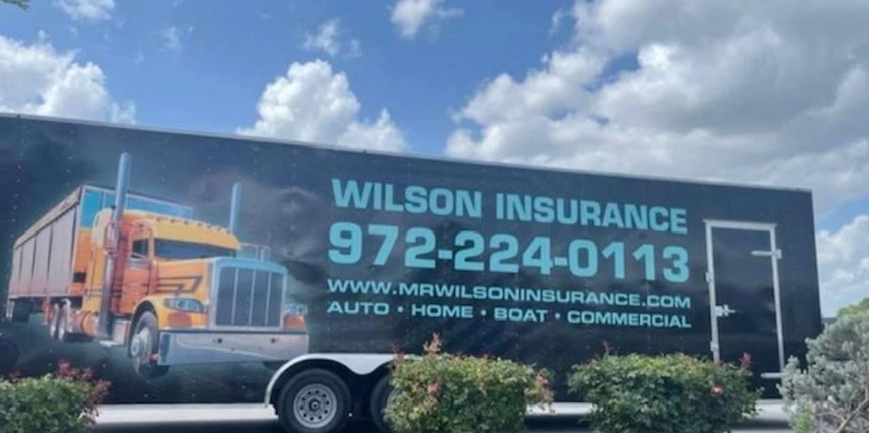 Truck trailer with Wilson Insurance ad and contact info.