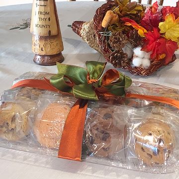 Packaged baked goods with ribbons, fall decorations in background.