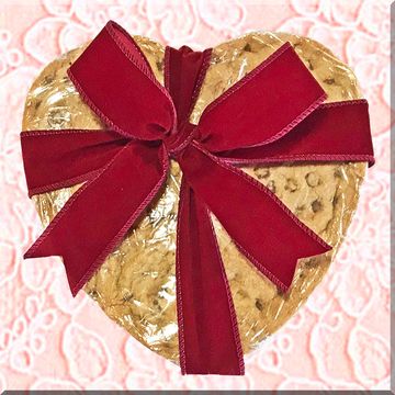 Heart-shaped cookie wrapped with a red bow.