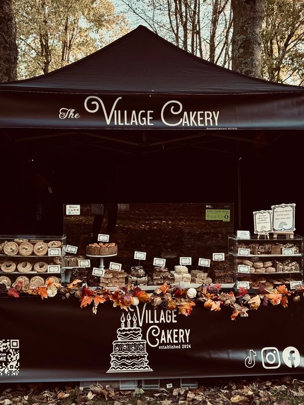 Outdoor bakery stall decorated with autumn leaves and various baked goods.