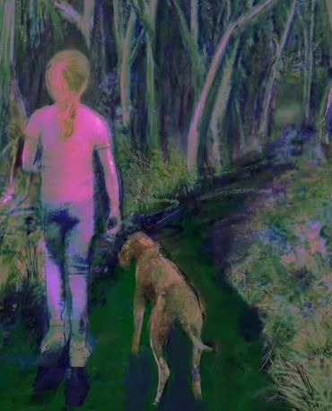 Person walking a dog on a forest path.