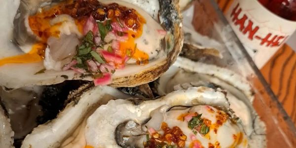 Fresh oysters topped with spicy sauce and herbs.
