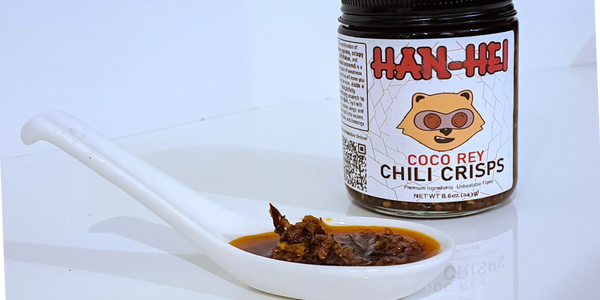 Jar of Han-Hei Coco Rey Chili Crisps with a spoonful of chili crisp sauce.