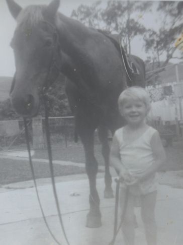 a small kid is holding horse rope