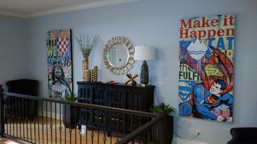 Hallway decorated with superhero and Star Wars artwork, a black cabinet, and gold accents.