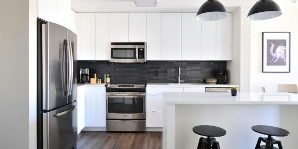 Modern kitchen with white cabinets and stainless steel appliances.