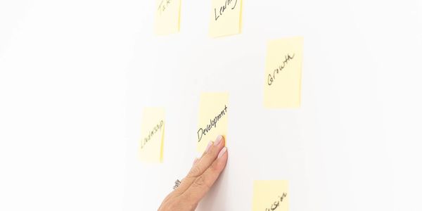 A white wall with hand & 6 yellow stickies: Talent
Learning
Development
Growth
Leadership
Succession