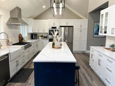 Modern kitchen with white cabinetry and blue island.