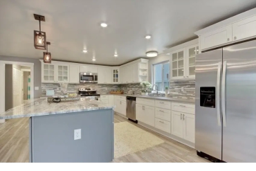 Modern kitchen with white cabinetry and stainless steel appliances.