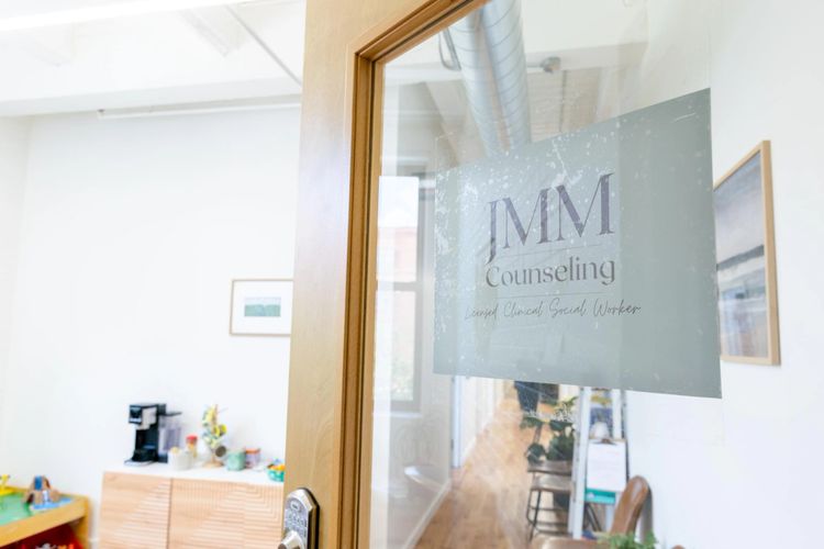 Glass door with JMM Counseling sign at a social worker's office.