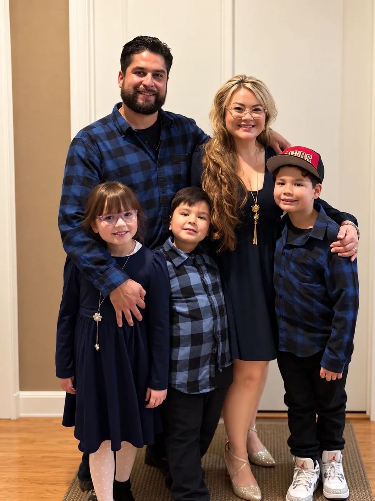Smiling family of five dressed in coordinated blues.
