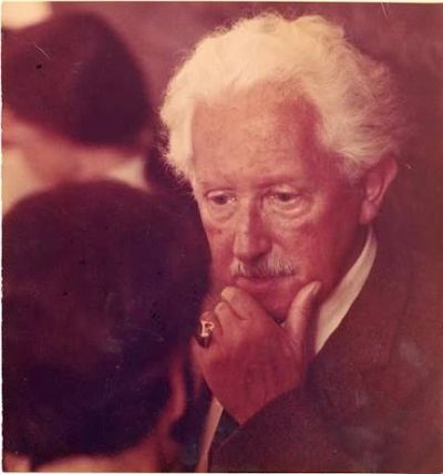 Elderly man with white hair and mustache in deep thought.