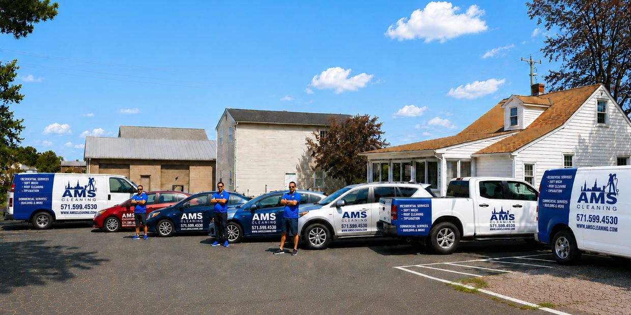 AMS Cleaning team posing with their branded vehicles in a parking lot on a sunny day.