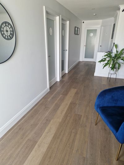 Modern hallway with white doors and wooden flooring.