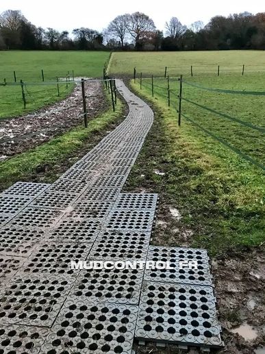 Chemin entre les paddocks de chevaux stabilisé avec des dalles.