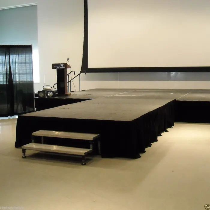 Empty stage with podium and large screen in a conference room.