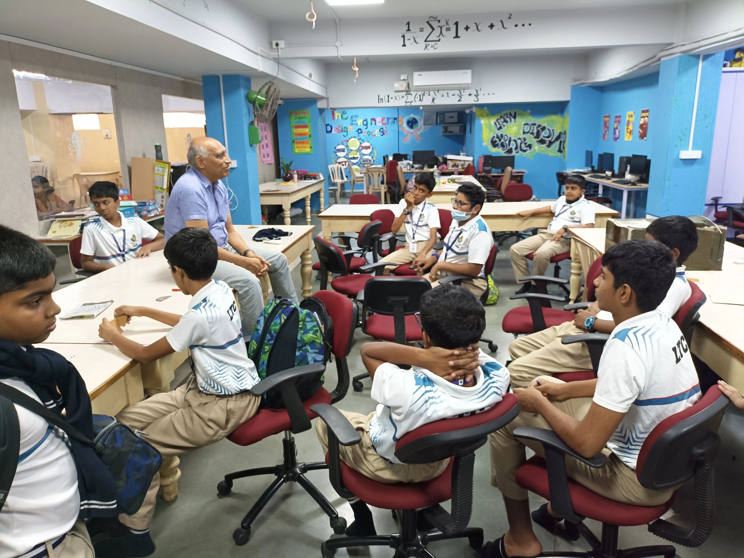 Teacher discussing with students in a classroom.