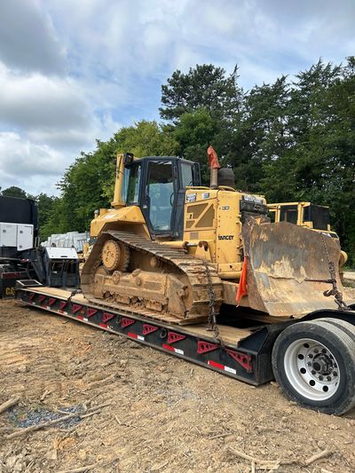 Yellow bulldozer loaded on a flatbed truck.