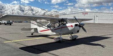 A small white propeller airplane on the runway.