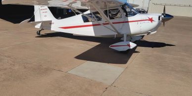 White small airplane on concrete tarmac.