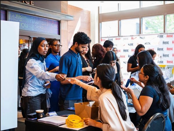 People exchanging tickets at an event check-in table.