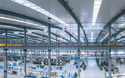 A spacious, modern industrial warehouse with machinery and equipment.