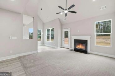 Bright living room with fireplace and ceiling fan.