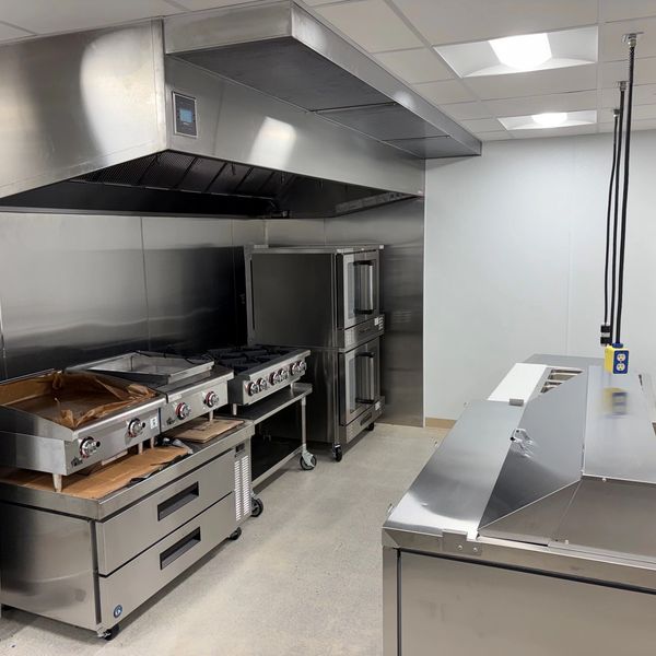 Commercial kitchen with stainless steel appliances.