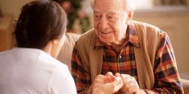 Older man smiling while talking to counselor.