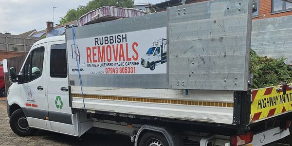 A rubbish removal truck parked near a residential area.