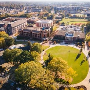 Aerial view of a college campus with buildings and green spaces.