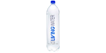 A clear glass filled to the brim with fresh and pure drinking water. The glass sits on a clean, whit